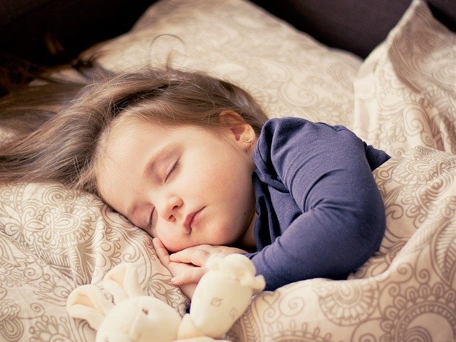 ベッドでぐっすりと眠る子供