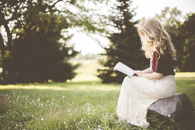 自然の中でゆったり本を読む女性