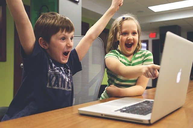 パソコンの画面を見て大喜びする2人の子供